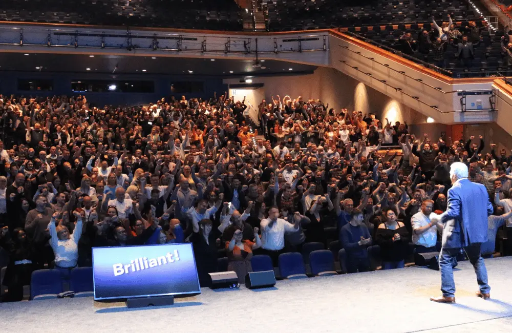 Michael Heppell presenting How to Be Brilliant to a large arena audience